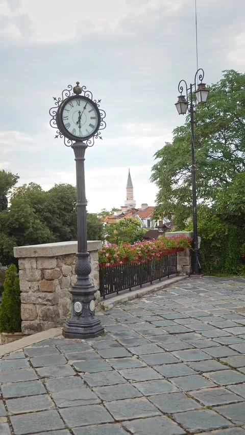 Vertical antique double-faced post clock with Ottoman mosque minaret in Plovdiv Stock Footage 346832579