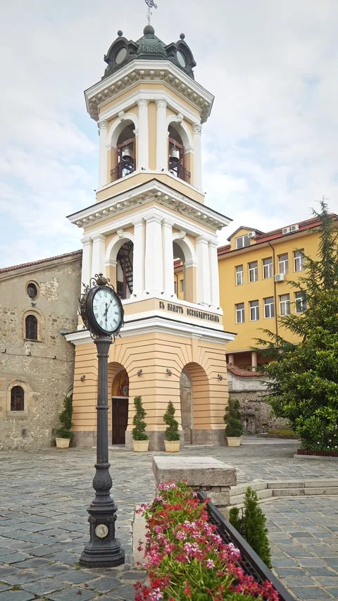 Vertical antique double-faced post clock and Holy Mother of God Church in Stock Footage 346832599