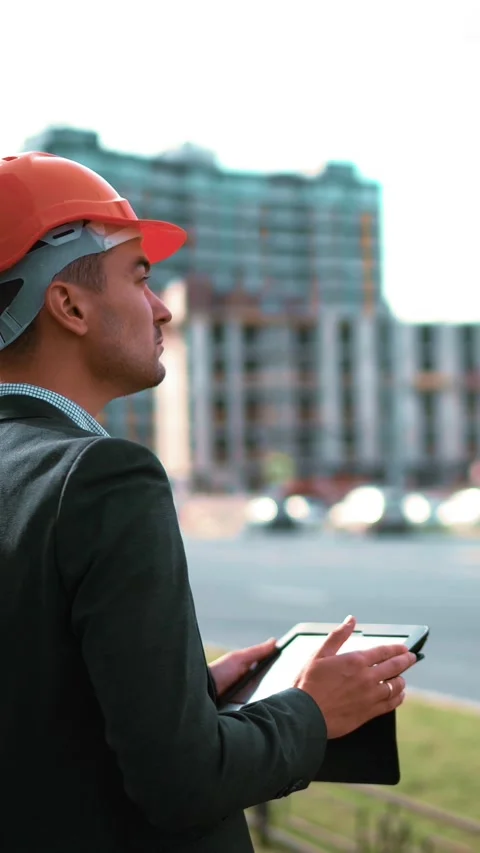 Vertical of Architect looking digital pad and comparing project with building Stock Footage 305516027