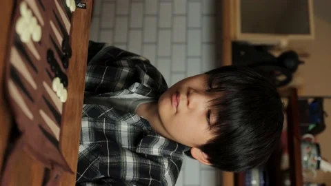 Vertical : Asian boy playing backgammon at home. Stock Footage 224232550