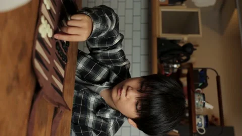 Vertical : Asian boy playing backgammon at home. Stock Footage 224233022