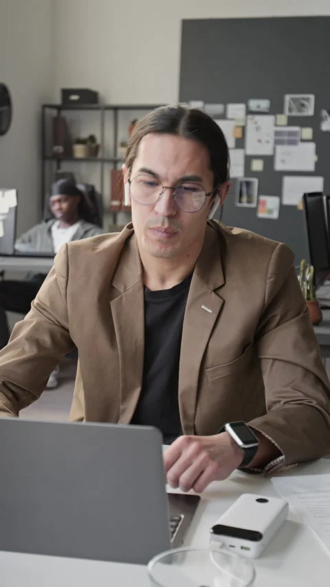 Vertical of Asian Man Closing Laptop before Leaving Office after Workday Stock Footage 336714726