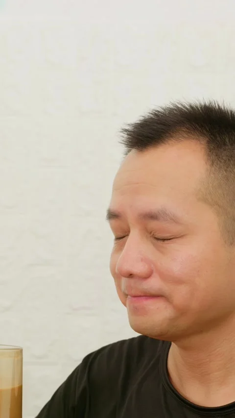 Vertical Asian man looks surprised and delighted after tasting coffee. Stock Footage 342471420