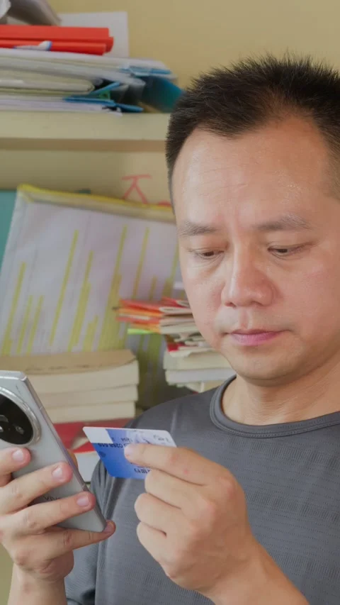 Vertical Asian man using credit card and smartphone for payment Stock Footage 342472457