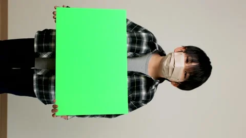Vertical : Asian young boy with mask on holding green board. Chromakey edit. Stock Footage 221357166