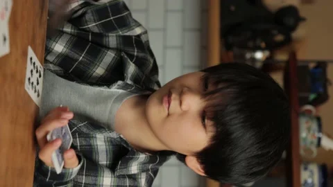 Vertical : Asian young boy playing cards at home. Speed Card. Stock Footage 221402413