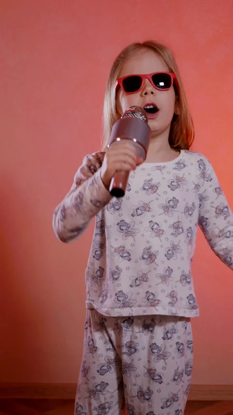 Vertical. Aspiring pop star in patterned pajamas belts out a tune and dances fun Stock Footage 307289430