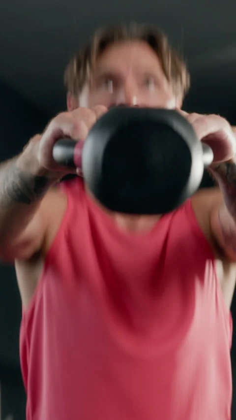 Vertical of Athletic Man Doing Kettlebell Swings in Gym for Strength Training Stock Footage 345200280