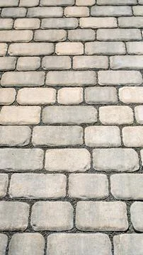 Vertical background of gray concrete paving stones with a repeating pattern.. Stock Photos