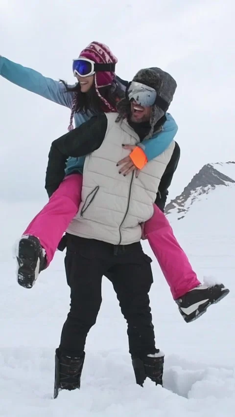 Vertical background of laughing couple enjoy romantic piggyback ride in sno.. Stock-Footage 311649843