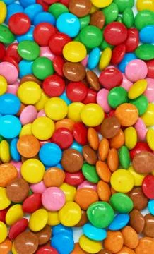 Vertical background many colored small candies Stock Photos