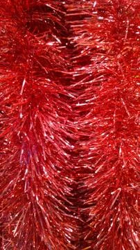 Vertical background of red shiny Classic Tinsel Garland. Traditional Christmas Stock Photos