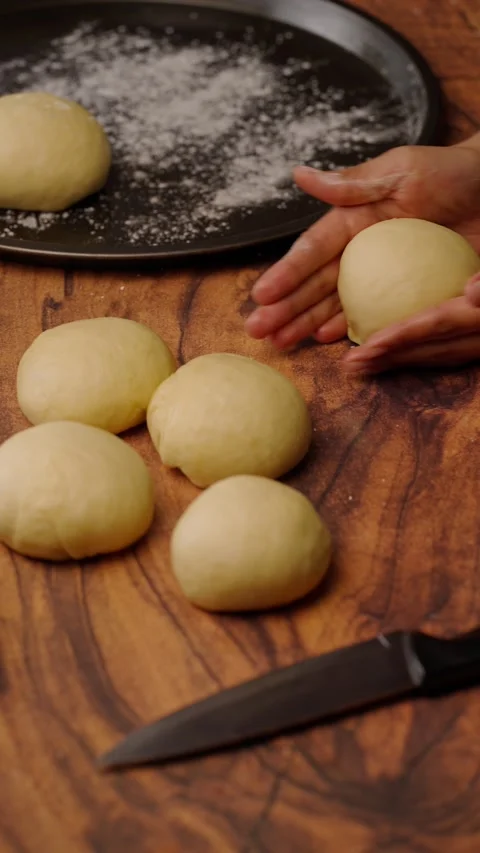 Vertical bakery video, rolling yeast dough to make homemade bread Stock Footage 282499420