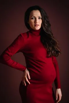 Vertical beautiful calm dark haired pregnant woman red dress, posing. Close up Stock Photos