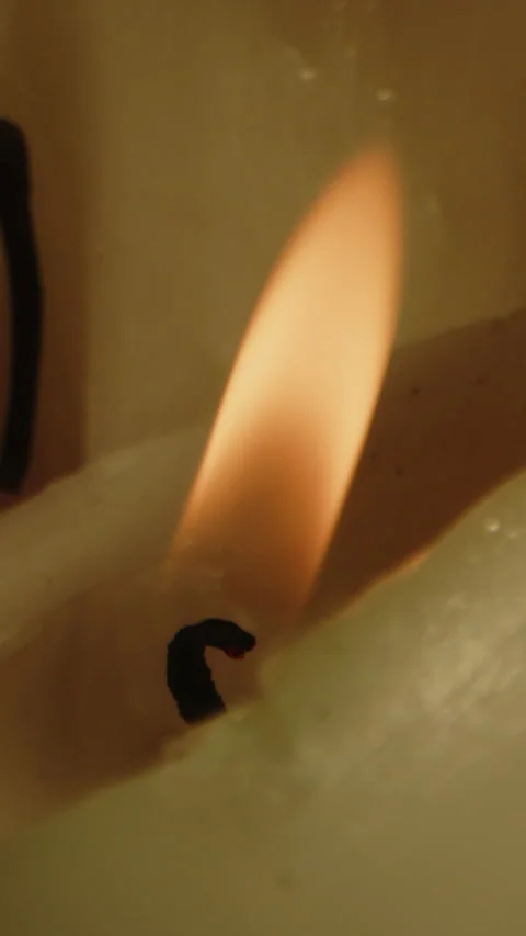 Vertical Beautiful macro of an burning candle and the orange fire being blown Stock Footage 336374310