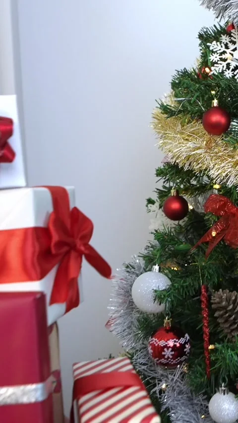Vertical Beautifully wrapped gift boxes under Christmas decoration tree at home Stock Footage 313075860