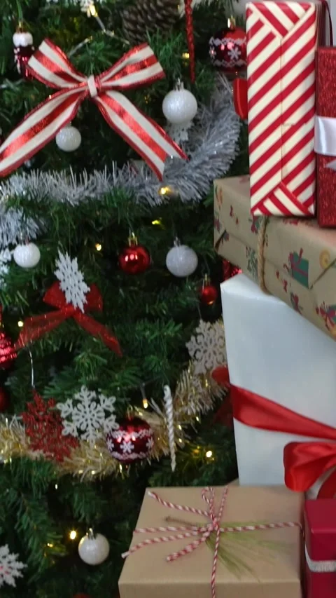 Vertical Beautifully wrapped gift boxes under Christmas decoration tree at home Stock Footage 315237317