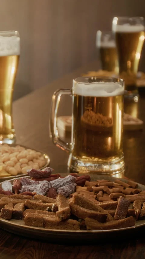 Vertical of Beer Glasses with Snacks Displayed on Pub Counter Stock Footage 335812431