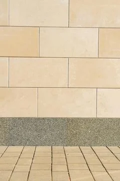 Vertical Beige Stone Wall Cladding with Granite Base and Paving Stock Photos