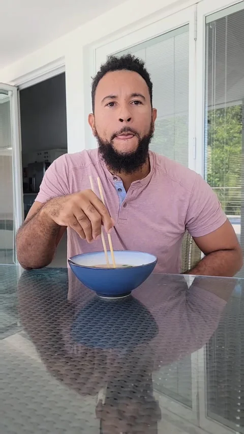 Vertical Black Afro Caribbean Man eating Vietnamese Pho with Chopsticks 4K Video stock 188541561
