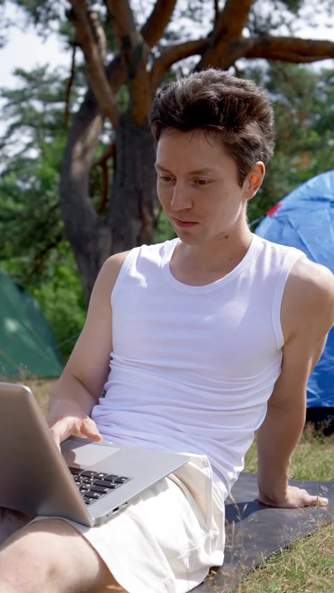 Vertical of Black-haired freelancer enjoys working in fresh air in camp Stock Footage 276385252