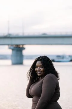 Vertical black-haired smiling plump African Afro-American, interracial woman Stock Photos