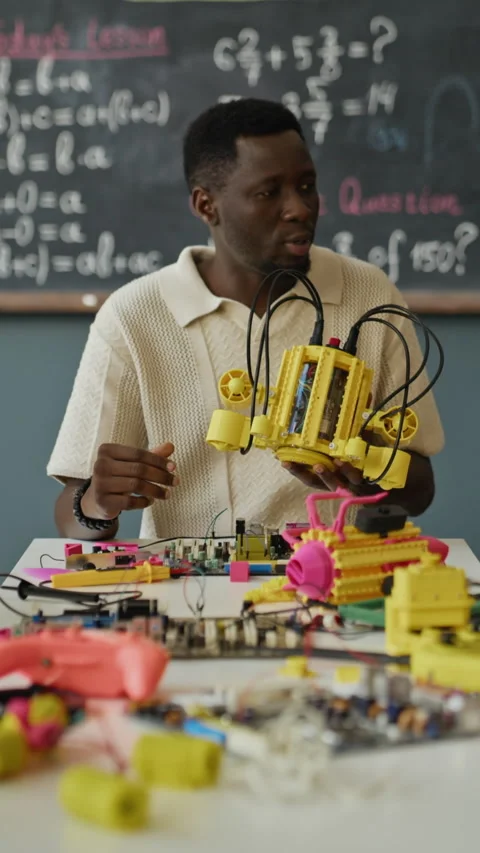 Vertical of Black Male Teacher Explaining Robotic Device in Stem Classroom Stock Footage 340547060