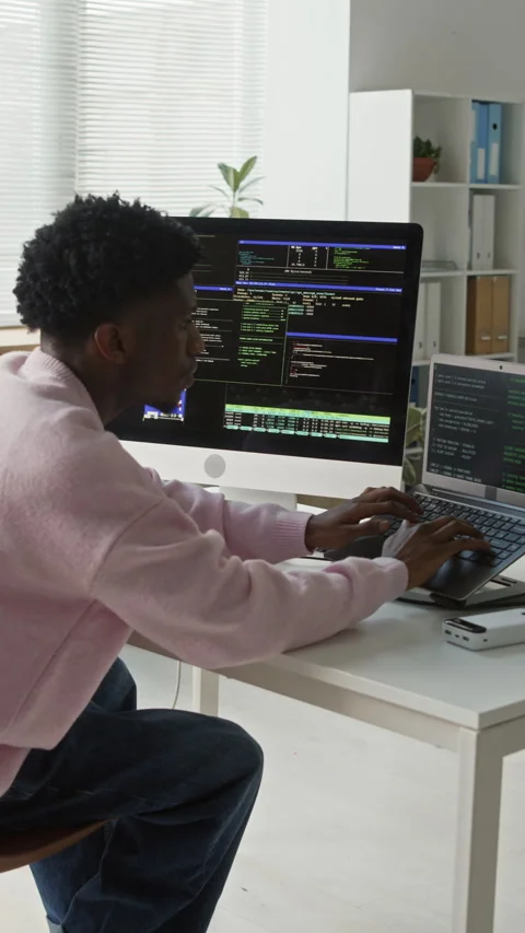 Vertical of Black Male Web Developer Typing Code on Computers at Office Desk Video stock 330129802