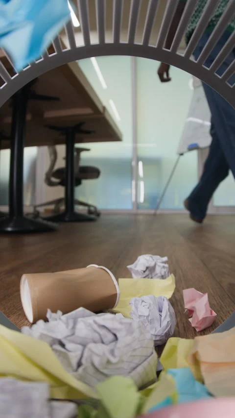 Vertical of Black Man Cleaning Office Floor and Throwing Waste into Trash Can Stock Footage 343701741