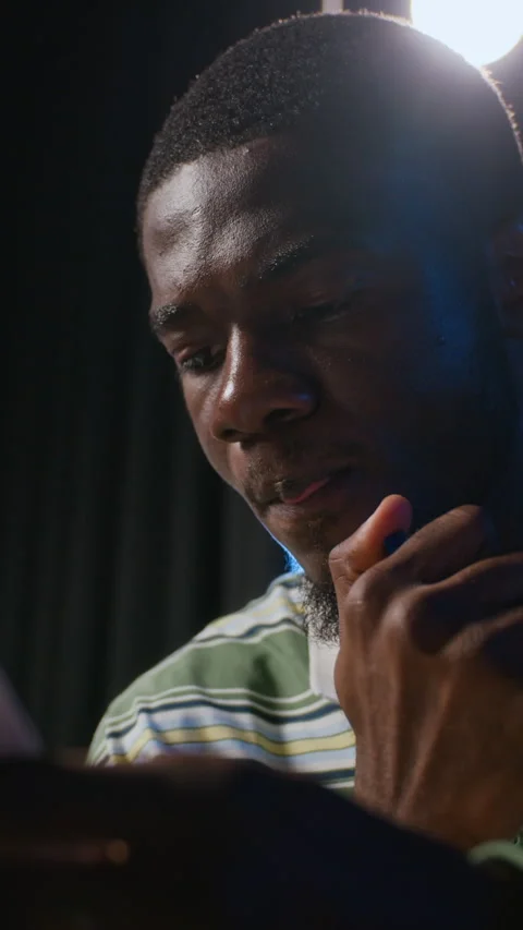 Vertical of Black Man Reading Script under Spotlight during Theater Rehearsal Stock Footage 344535301