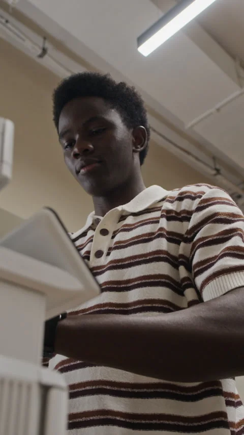 Vertical of Black Man Scanning Paper Documents on Office Copier Machine Stock Footage 343701736