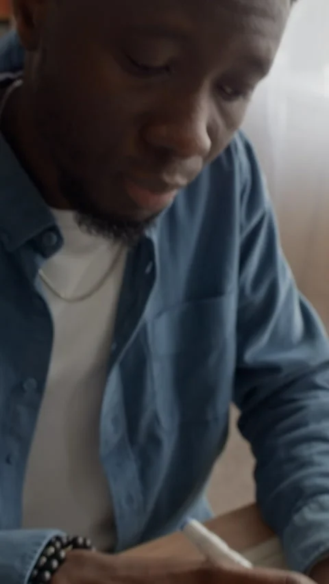 Vertical of Black Man Using Calculator to Organize Finances at Messy Table Stock Footage 321863071