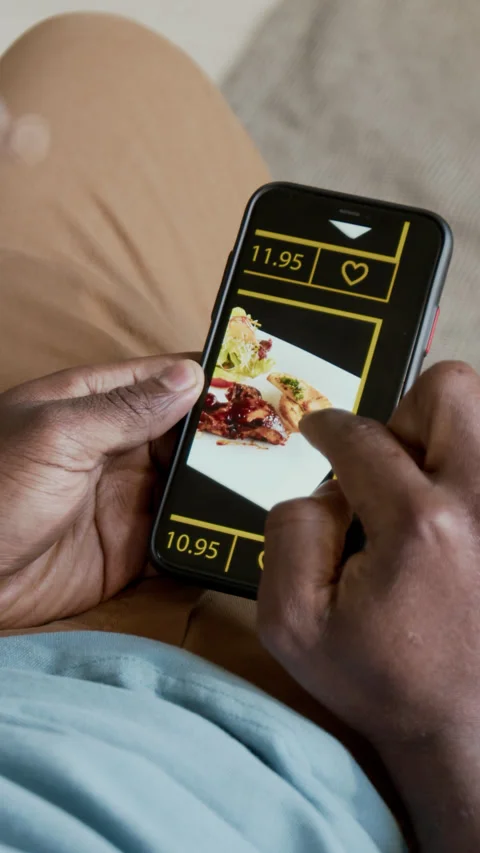 Vertical of Black Man Viewing Meal Photos on Food Delivery Smartphone App Stock Footage 302503690