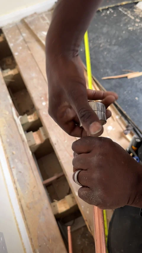 Vertical. Black plumber cutting copper pipe using manual cutter 库存影片 297259452