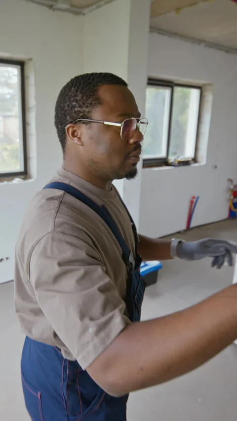 Vertical of Black Plumber Working on Heating Pipes during Home Renovation Stock Footage 340613207