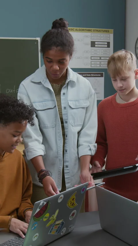 Vertical of Black Schoolgirl Showing Coding Project to Classmates on Tablet Video stock 318729165