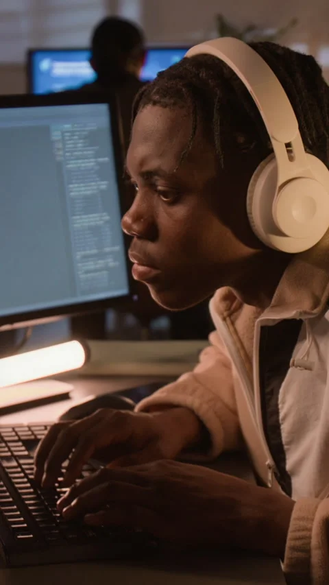Vertical of Black Software Developer Wearing Headphones Coding in Office Stock Footage 336708117