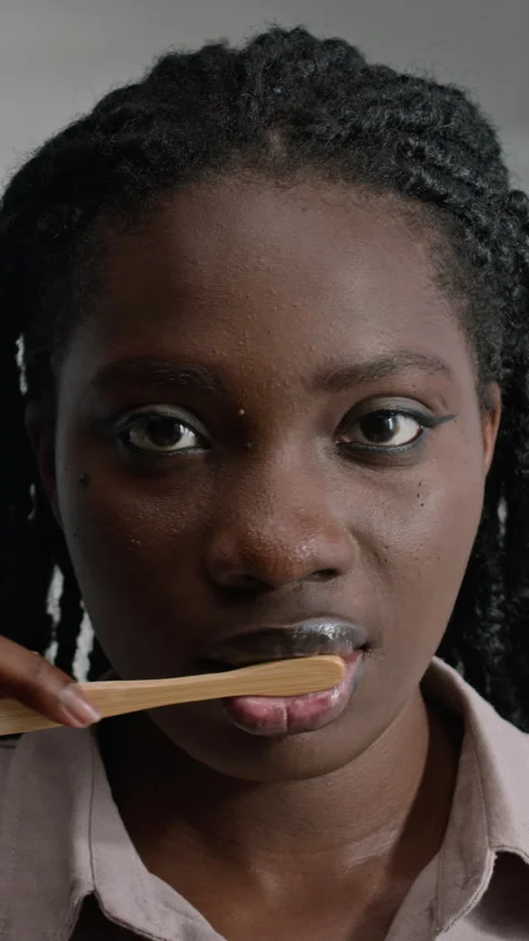 Vertical of Black Woman Brushing Teeth in Bathroom Stock Footage 291825946
