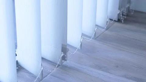 Vertical blinds with light filtering through in a modern interior setting Stock Photos