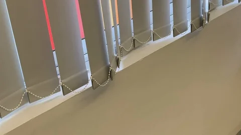 Vertical blinds undulate from soft air movement seen with diagonal orientation 스톡 동영상 114496848