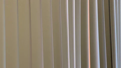 Vertical blinds undulate from soft air movement Stock Footage 114497880