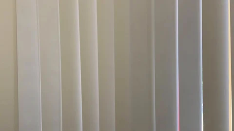 Vertical blinds undulate from soft air movement Vídeo Stock 114497918
