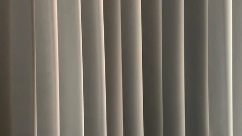 Vertical blinds undulate from soft air movement Stock Footage 114499023