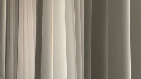 Vertical blinds undulate from soft air movement Stock Footage 114499373