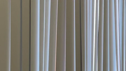 Vertical blinds undulate from soft air movement Vídeo Stock 114502396