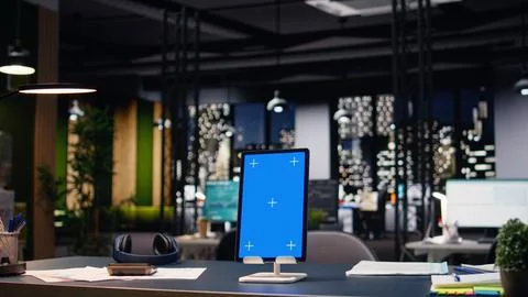 Vertical blue screen tablet in empty corporate office with spacious open space Stock Photos
