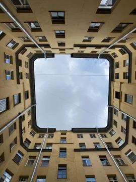 Vertical bottom up view of a geometric well courtyard in a dense historical.. Stock Photos