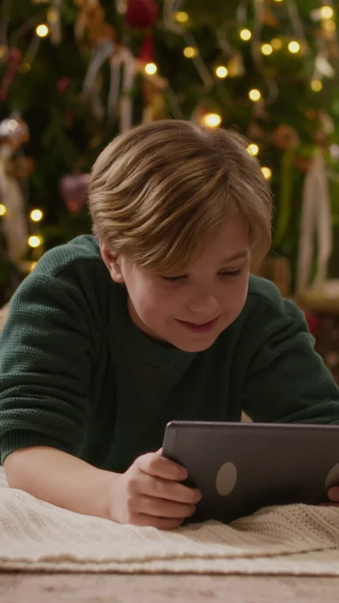 Vertical of Boy Using Digital Tablet near Christmas Tree during Holidays Stock-Footage 346884350