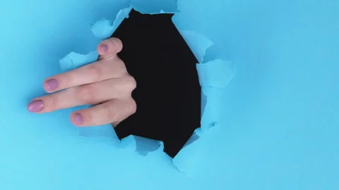 Vertical breakthrough hand fingers torn paper hole Stock Footage 252106462