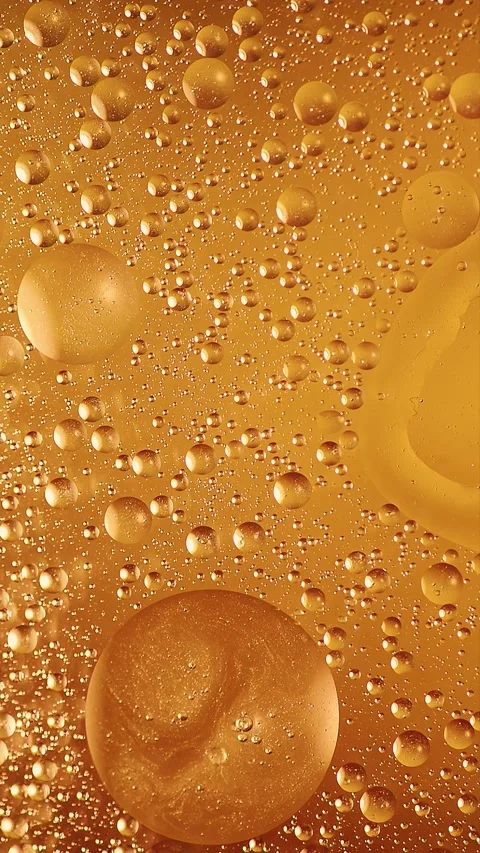 Vertical bright golden oil bubbles splash and fluid pattern change Stock Footage 341825057